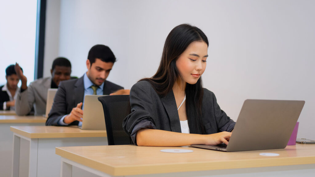 Candidates on separate desks taking exams on laptops